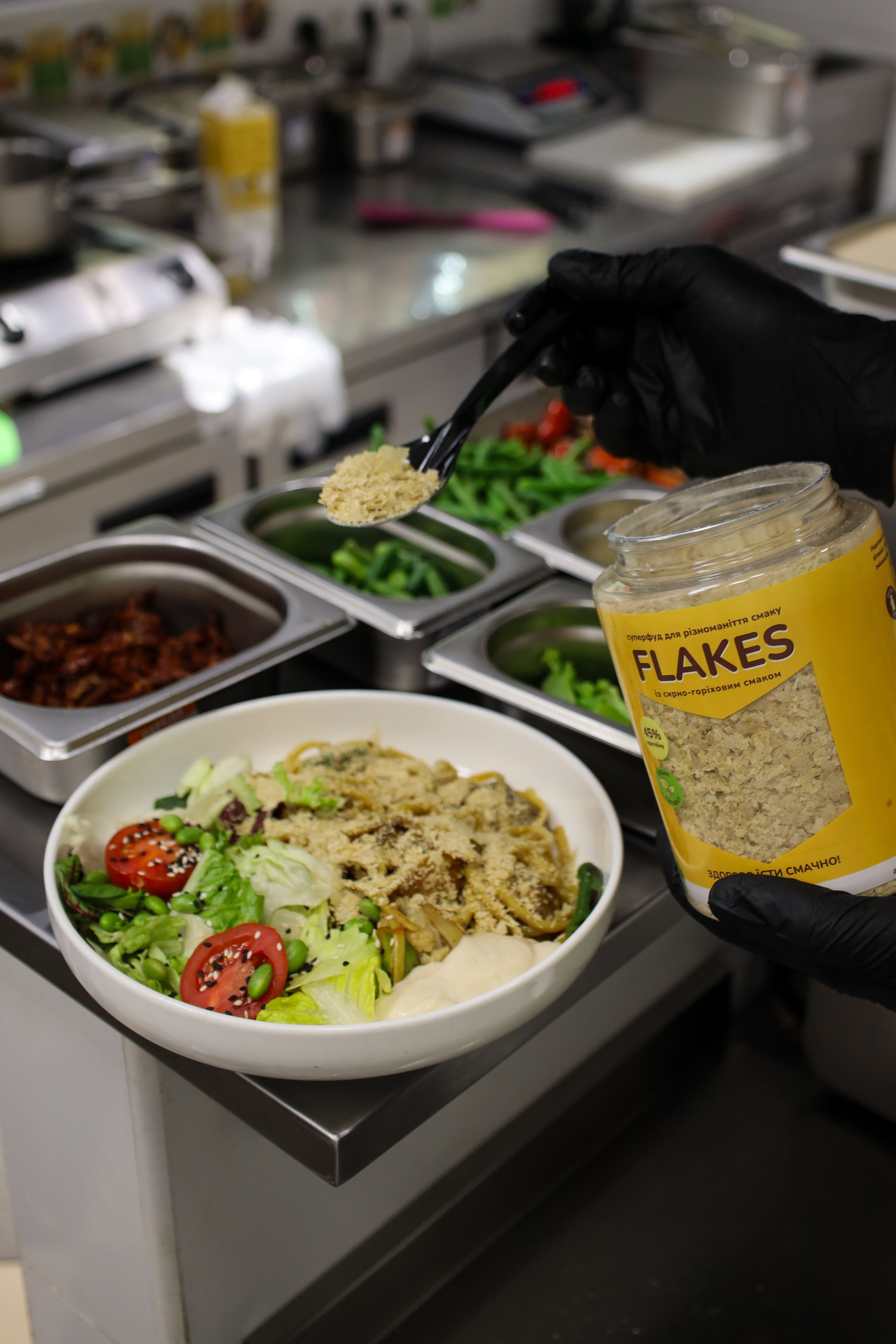 Кухар додає Flakes до страви у ресторані Tomatina