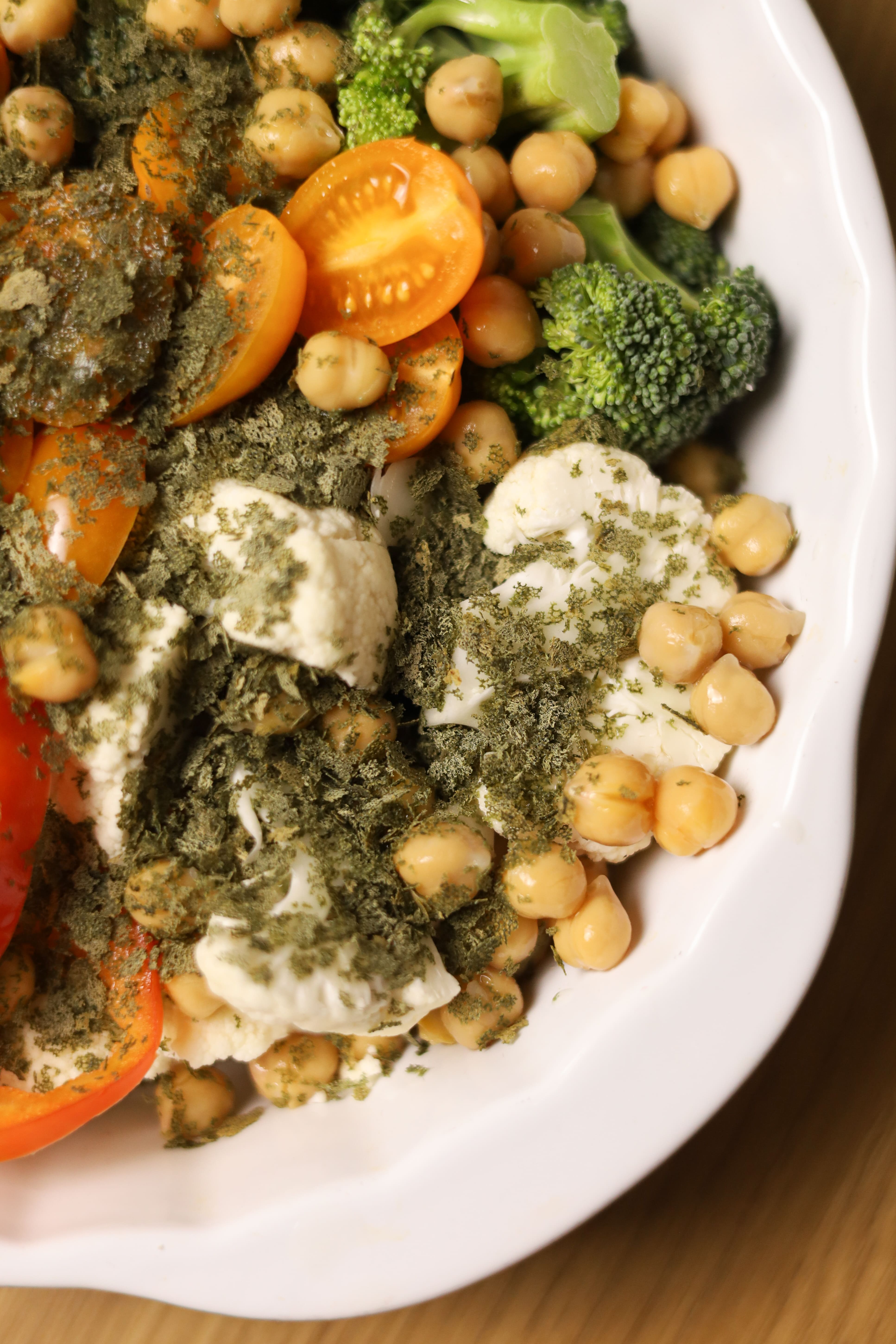 Крупний план овочів посипаних Flakes зі спіруліною перед запіканням